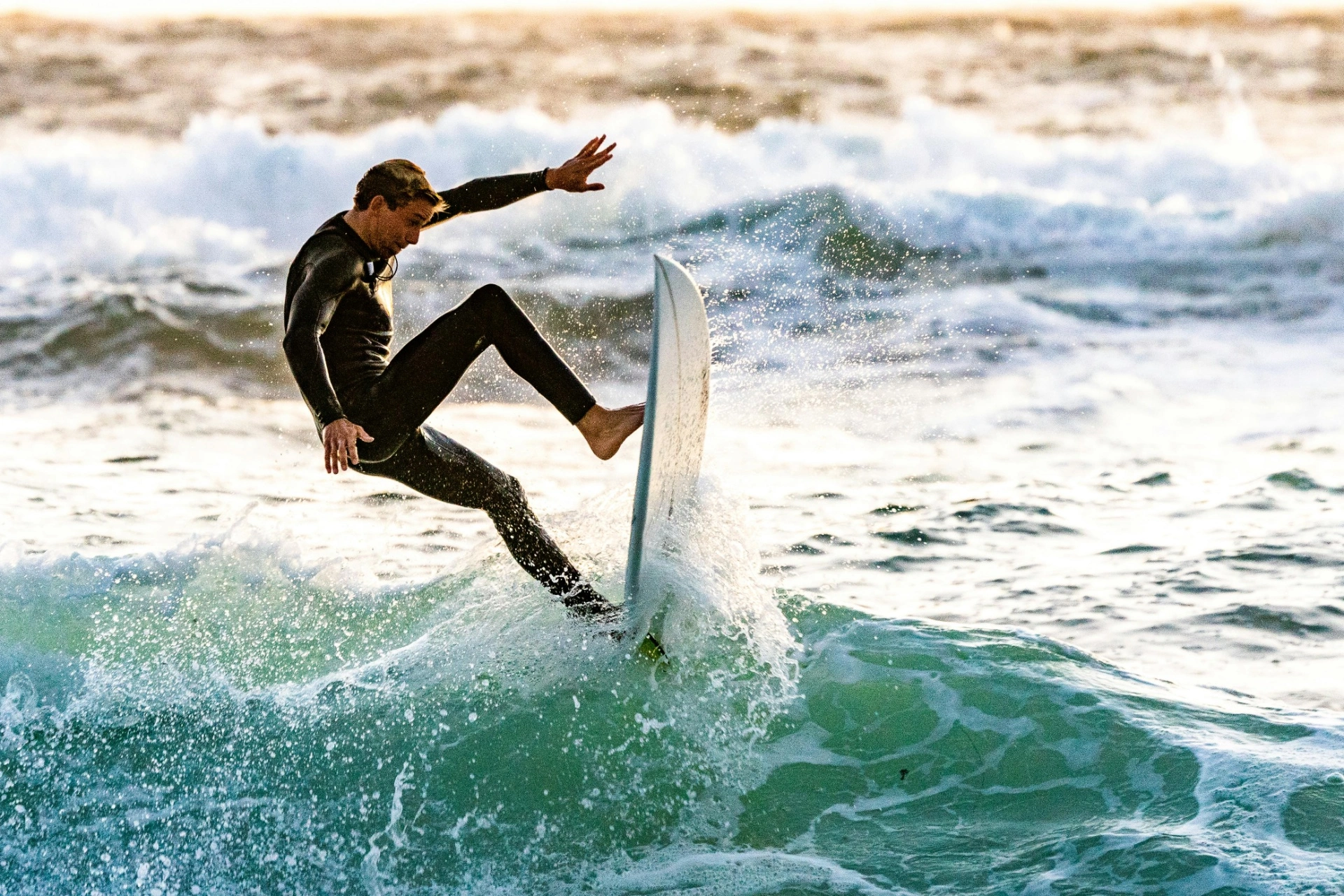 A man riding a surfboard on top of a wave.