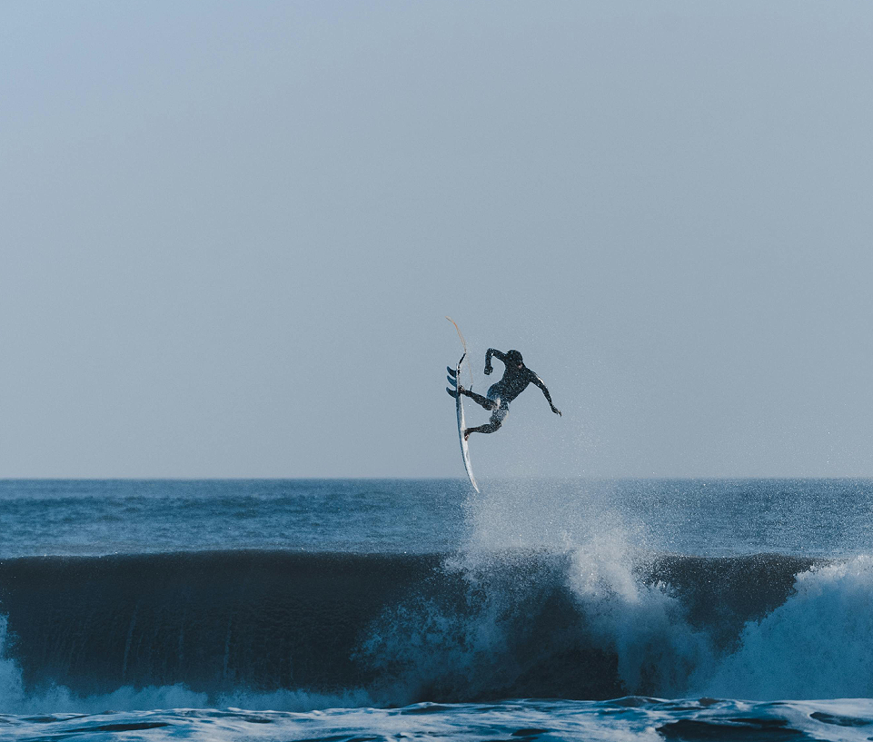 A man surfing on the waves in the ocean.